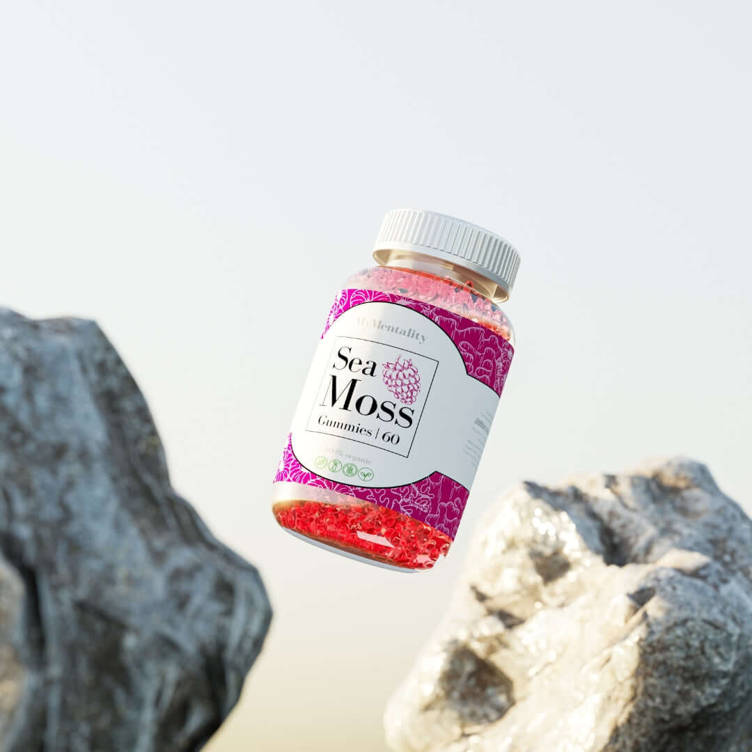 Raspberry Sea Moss Gummies bottle surrounded by rocks, showcasing holistic wellness and nutrient-rich vegan supplements.
